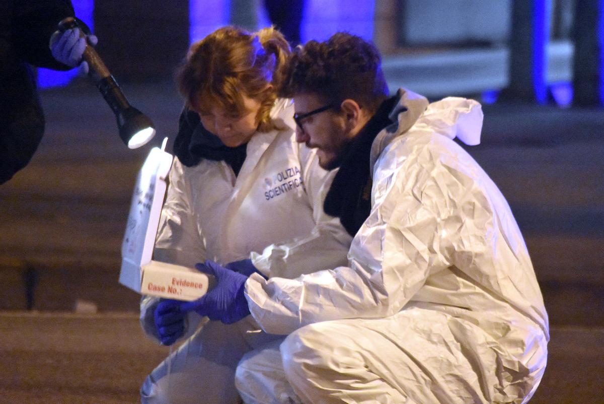 Italian forensic police collect evidence in an area after a shootout between police and a man near a train station in Milan's Sesto San Giovanni neighborhood, Italy, early Friday, Dec. 23, 2016. (AP Photo/Daniele Bennati)