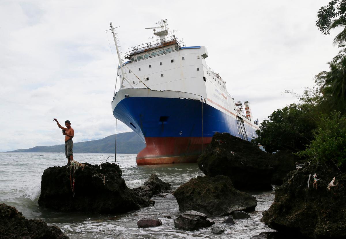The passenger ferry Shuttle Roro 5 which rests by the shore after being swept by typhoon Nock-Ten a day after Christmas at Mabini township, Batangas province south of Manila, Philippines on Dec. 26, 2016. (AP Photo/Bullit Marquez)