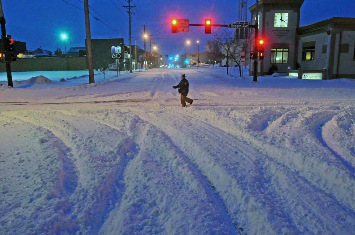 Madori Griffin, who says her car was snowed in, makes her way through an intersection while walking to work in the intensive care unit of Sanford Hospital in Bismarck, N.D., on, Dec. 26, 2016. (Tom Stromme/The Bismarck Tribune via AP)