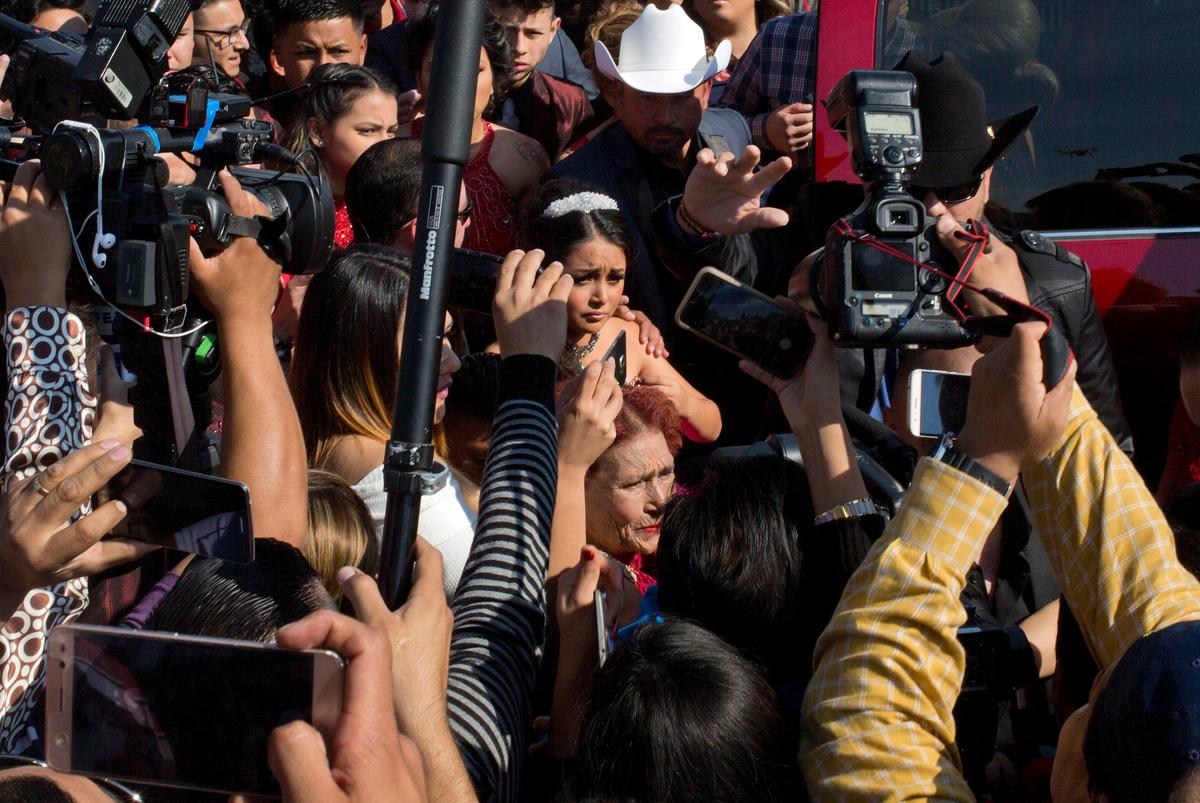 Rubi Ibarra arrives at the site of a Mass that is part of her down-home 15th birthday party, surrounded by a horde of journalists, in the village of La Joya, San Luis Potosi State, Mexico on Dec. 26, 2016. (AP Photo/Enric Marti)