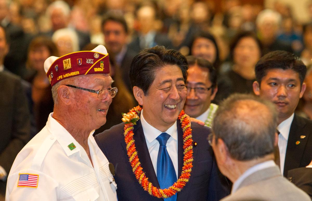 Japanese Prime Minister Shinzo Abe (C) greets guests at a dinner held in Abe's honor, in Honolulu on Dec. 26, 2016. (AP Photo/Marco Garcia)