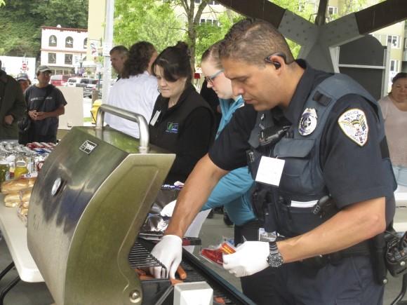In this file photo, Juneau Police Officer Ken Colon grills hot dogs during a gathering sponsored by the police department to allow people to take a stand against violence and to celebrate diversity within the community in Juneau, Alaska. (AP Photo/Becky Bohrer, File)