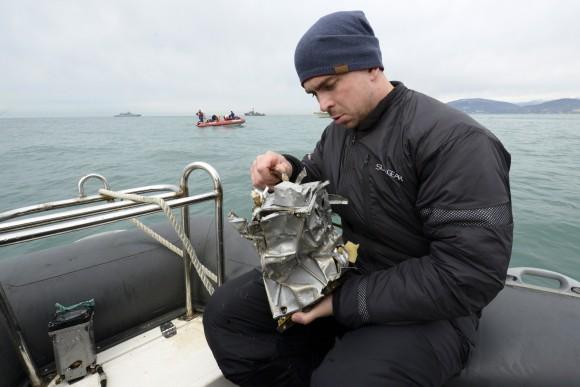 A Russian Emergency Ministry diver inspects a fragment of a plane in the Black Sea, outside Sochi, Russia, on Dec. 27, 2016. (AP Photo/Viktor Klyushin)