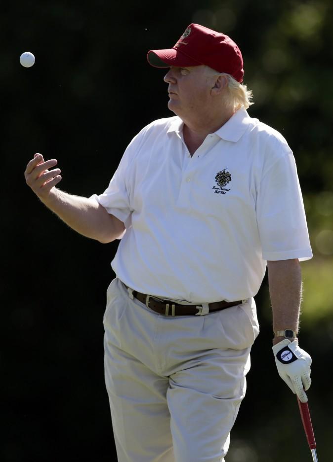 Donald Trump tosses a ball while standing on the 14th fairway during a pro-am round of the AT&T National golf tournament at Congressional Country Club, Wednesday, June 27, 2012, in Bethesda, Md. (AP Photo/Patrick Semansky)