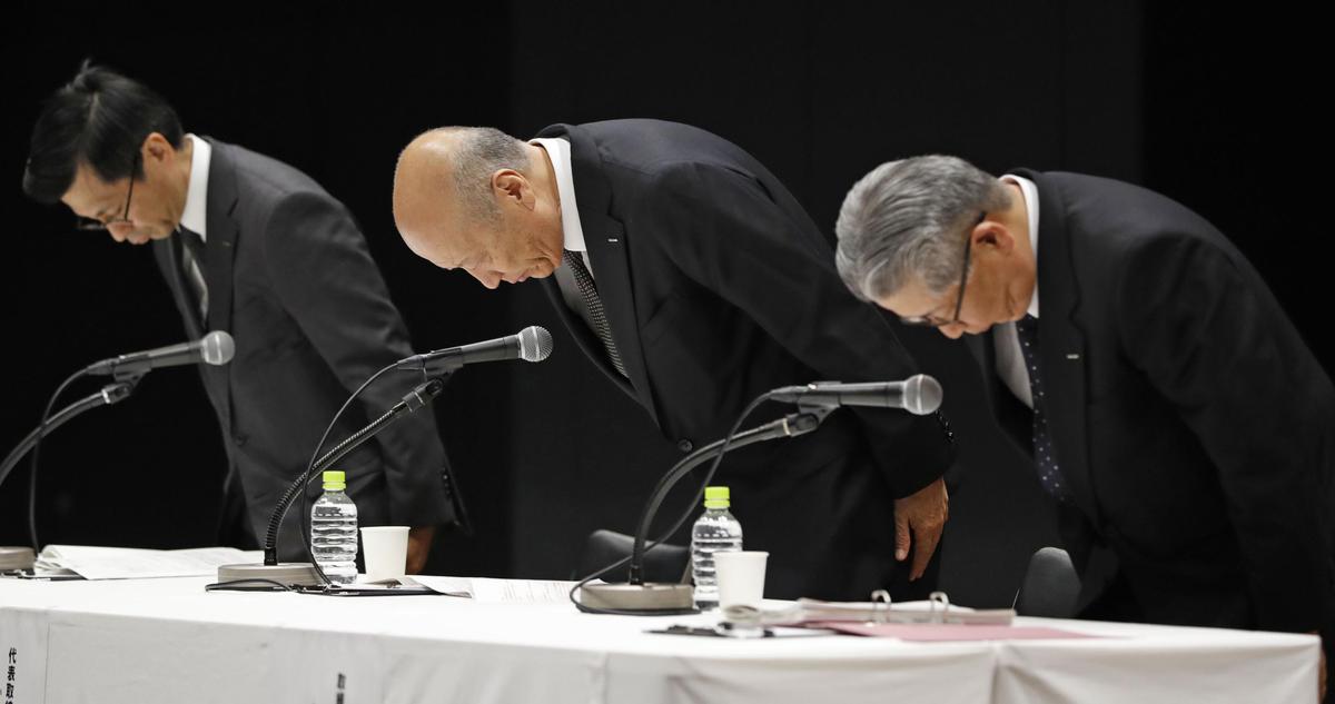President of the top Japanese advertising company Dentsu Inc. Tadashi Ishii (C) bows with other senior executives during a press conference at the company's headquarters in Tokyo, on Dec. 28, 2016. (Kyodo News via AP)