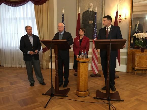 Latvian President Raimonds Vejonis, right, looks at US Sen. John McCain centre left, during a press conference, in Riga, Latvia, on Dec. 28, 2016. (AP Photo/Vitnija Saldava)