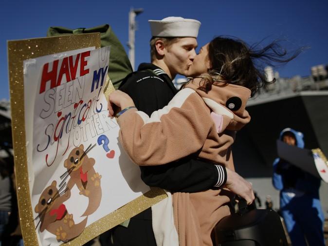 Melanie Till, in costume and carrying a sign reading "Have u seen my significant otter?", welcomes home her husband P.O. 3rd Class David Till at Naval Station Norfolk, in Norfolk, Va., on Dec, 30, 2016, from a seven-month deployment to the Middle East and the Mediterranean Sea. (Stephen M. Katz/The Virginian-Pilot via AP)