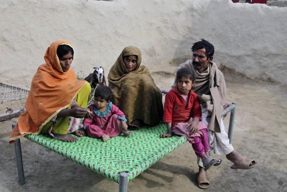 Wazir Ahmed (R) who married his underage daughter to a 36 year-old man, sits with his wives in Jampur, Pakistan, on Dec. 21. (AP Photo/K.M. Chaudhry)
