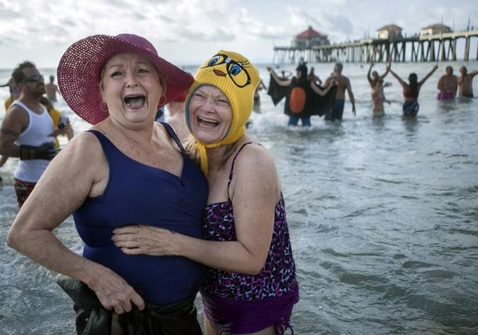 Shirley Lynch (L) and Lorri Combellick participate in the Surf City Splash plunge into the Pacific Ocean in Huntington Beach, Calif., on Jan. 1, 2017. (Mindy Schauer/The Orange County Register via AP)