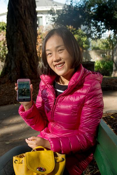 Peiqui Gu shows a cell phone photo of her father when he visited her in the summer of 2016. She was separated from her parents for two years, the longest time she ever spent away from them. Her father "knows how hard I was trying to survive alone on the other side of the world by myself," Gu said. (Cat Rooney/Epoch Times)