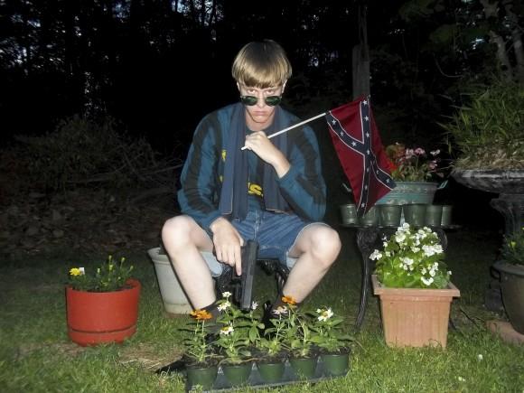 This file photo that appeared on Lastrhodesian.com, a website investigated by the FBI in connection with Dylann Roof, shows him posing for a photo holding a Confederate flag. Roof, who would later admit he wanted to start a race war, fatally shot eight black worshippers and their pastor at the Emanuel African Methodist Episcopal Church in Charleston, South Carolina. (Lastrhodesian.com via AP)