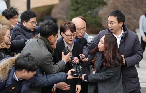 Yoon Jeon-chu, center, who has been President Park Geun-hye's aide since 2013, is questioned by media upon her arrival for the hearing in the impeachment trial of Park at the Constitutional Court in Seoul, South Korea, on Jan. 5, 2017. (AP Photo/Lee Jin-man)