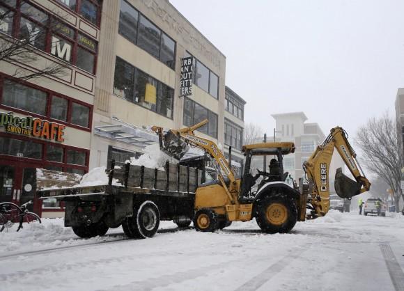 Road crews clear the street during a snowstorm in Norfolk, Va. on Jan. 7, 2016. Snow pounded a swath of Virginia on Saturday as hundreds crashed on icy roads, thousands lost power and blizzard warnings were issued along the East Coast. (AP Photo/Jason Hirschfeld)