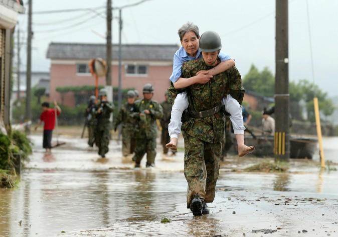 apanese soldiers help local residents evacuate from flooded area in Asakura, Fukuoka prefecture, on July 6, 2017. At least 15 people are missing after huge floods swept away houses in southern Japan, tearing up roads as roiling waters surged through villages, authorities said, after unprecedented rainfall. (STR/AFP/Getty Images)