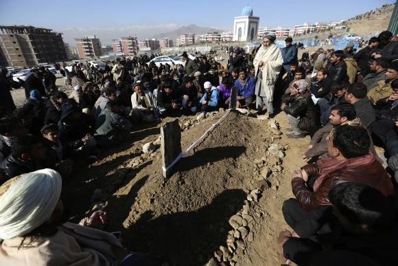 Villagers pray in front of the grave of a victim of Tuesday's two bombings in Kabul, Afghanistan, on Jan. 11, 2017. (AP Photo/Rahmat Gul)