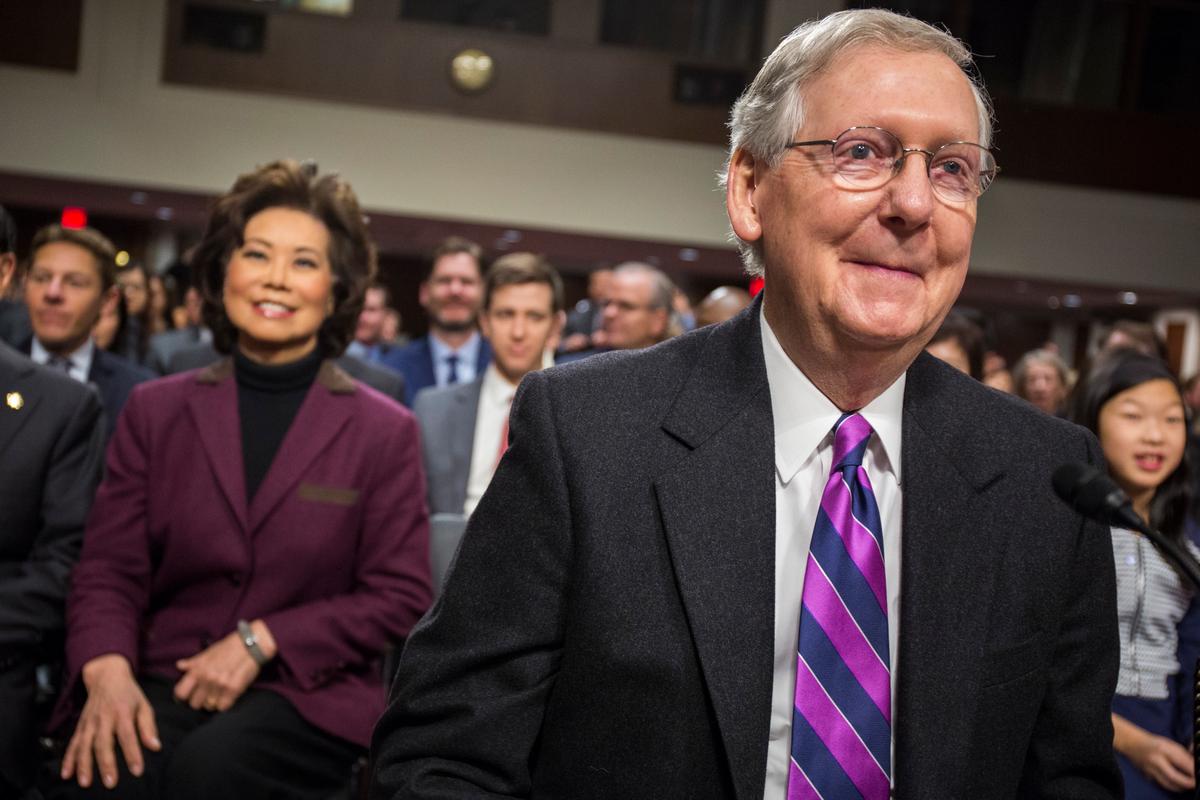 Transportation Secretary-designate Elaine Chao watches as her husband, Senate Majority Leader Mitch McConnell of Ky., arrives on Capitol Hill in Washington on Jan. 11, 2017. (AP Photo/Zach Gibson)