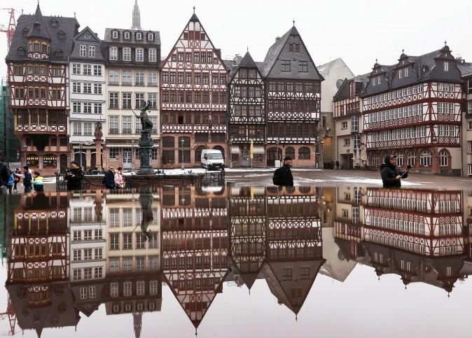 The timber-frame houses at the Roemerberg square are reflected in water in Frankfurt, Germany, on Jan. 11, 2017. (AP Photo/Michael Probst)