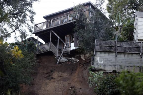 A home sits on the edge of a hill after a slab of concrete slid down a rain-soaked hillside in Los Angeles' Hollywood Hills neighborhood, on Jan. 11, 2017. (AP Photo/Damian Dovarganes)