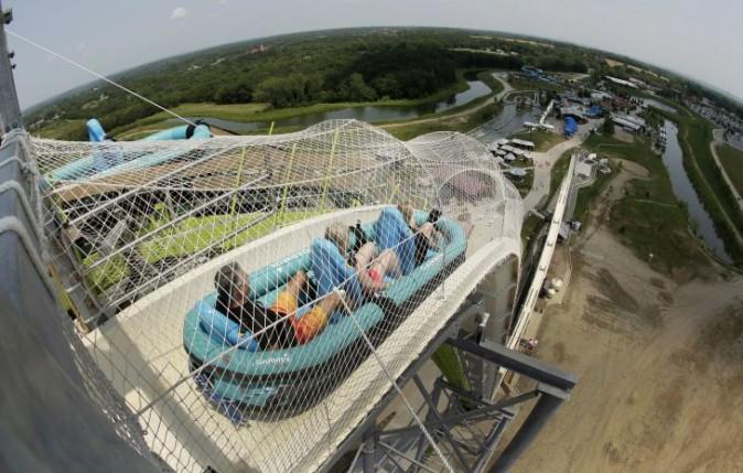 In this July 9, 2014, file photo, riders go down the water slide called "Verruckt" at Schlitterbahn Waterpark in Kansas City, Kan. The family of Caleb Schwab, a Kansas lawmaker's son who was killed Aug. 7, 2016, on the ride, has reached a settlement with the park's owner. Terms of the deal filed Wednesday in Kansas' Johnson County District Court involving Caleb Schwab's family were not released. A spokeswoman says the park's owners plan to follow through on demolishing the slide as announced in November. (AP Photo/Charlie Riedel, File)