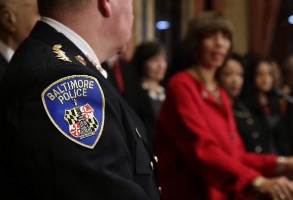 The Baltimore Police Department seal is seen on Commissioner Kevin Davis' uniform as he listens to Baltimore Mayor Catherine Pugh during a joint news conference in Baltimore, Thursday, Jan. 12, 2017, to announce the Department's commitment to a sweeping overhaul of its practices under a court-enforceable agreement with the federal government. (AP Photo/Patrick Semansky)