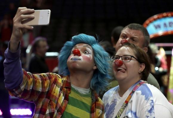 A Ringling Bros. and Barnum & Bailey clown takes a selfie with Jennifer and Kevin Fox, of Fort Pierce, Fla., on Jan. 14, 2017. (AP Photo/Chris O'Meara)