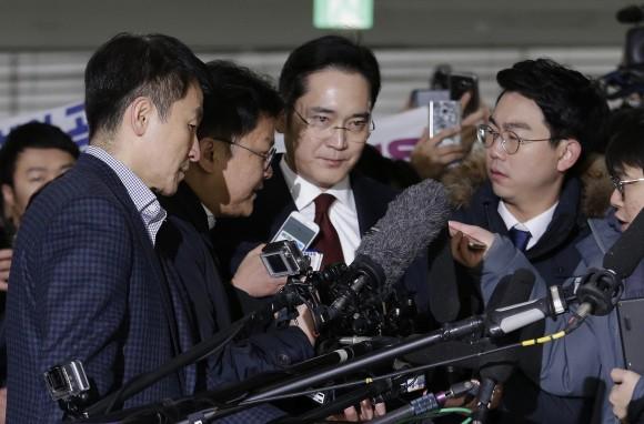 In this fie photo, Lee Jae-yong, center, vice chairman of Samsung Electronics, arrives to be questioned as a suspect in bribery case in the massive influence-peddling scandal that led to the president's impeachment at the office of the independent counsel in Seoul, South Korea. (AP Photo/Ahn Young-joon, Pool)