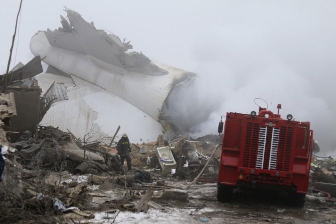 A Kyrgyz firefighter inspects a plane crash site outside Bishkek, Kyrgyzstan, on Jan. 16. A Turkish Boeing 747 cargo plane crashed just outside the Manas airport Monday morning killing people in the residential area adjacent to the Manas airport as well as those on the plane. (AP Photo/Azamat Imanaliev)