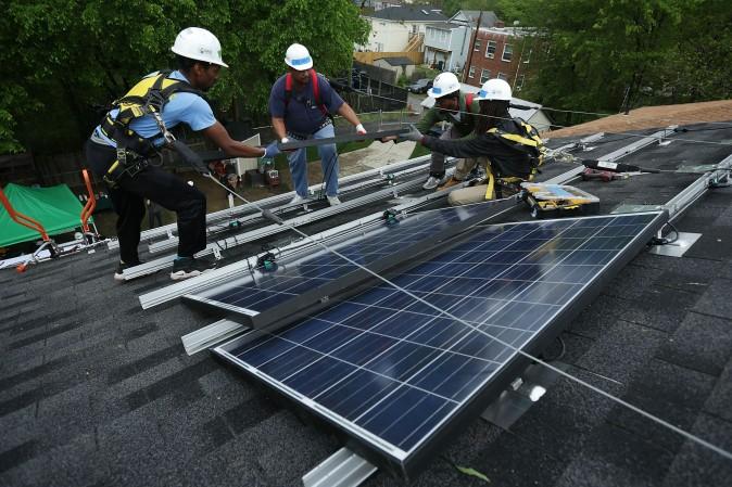 Workers install solar panels on a home in Washington on May 3, 2016. (Alex Wong/Getty Images)