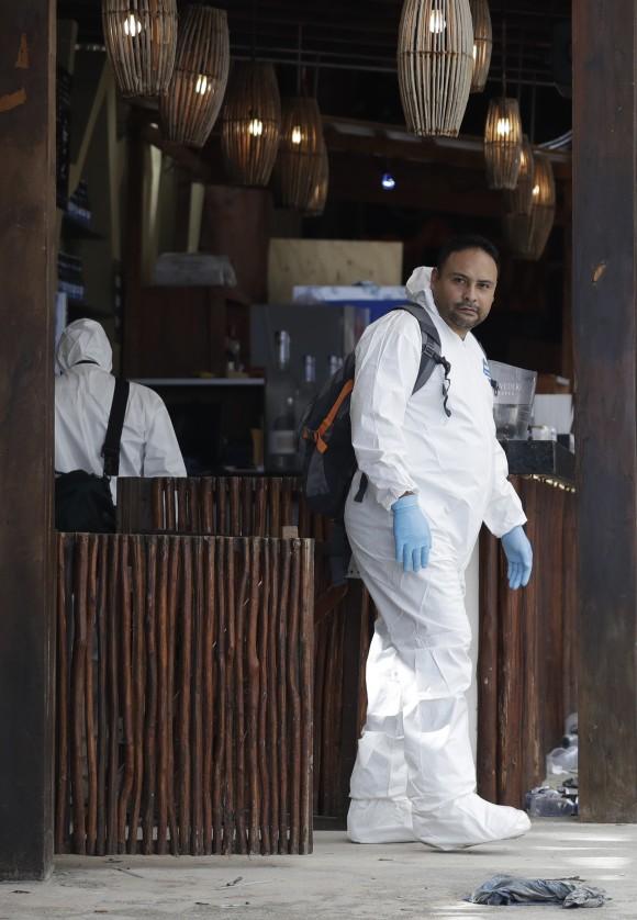 A forensic investigator walks inside the Blue Parrot club, one day after a deadly early morning shooting in Playa del Carmen, on Tuesday, Jan. 17, 2017. (AP Photo/Rebecca Blackwell)