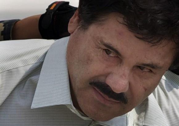 In this Feb. 22, 2014 file photo, Joaquin "El Chapo" Guzman is escorted to a helicopter in handcuffs by Mexican navy marines at a navy hanger in Mexico City. (AP Photo/Eduardo Verdugo)