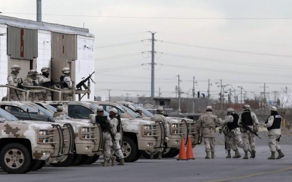 Soldiers wait at the airport after the extradition of drug lord Joaquin "El Chapo" Guzman in Ciudad Juarez, Mexico on Jan. 19, 2017. (AP Photo/Christian Torres)