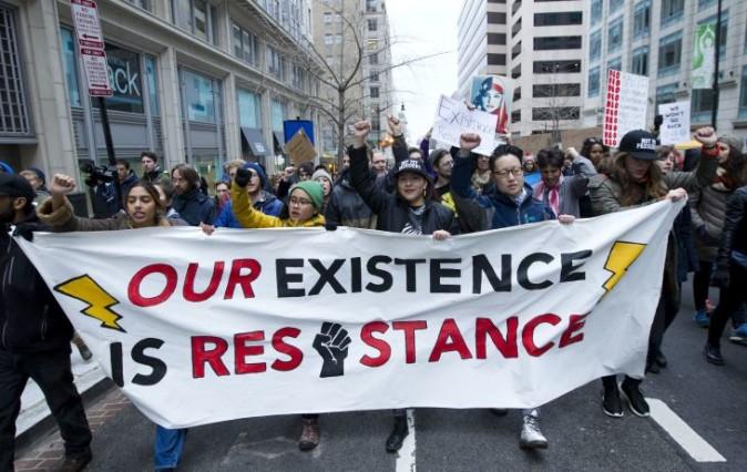 Demonstrators march near a inaugural security checkpoint entrance, Friday, Jan. 20, 2017 in Washington, ahead of President-elect Donald Trump's inauguration. ( AP Photo/Jose Luis Magana)