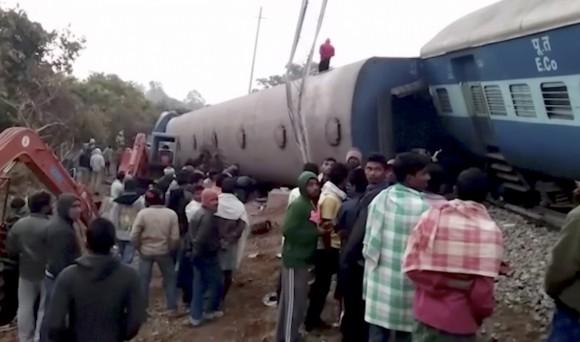 Rescuers and onlookers stand around coaches of a derailed passenger train in Kuneru, Andhra Pradesh, southern India, on Jan. 22, 2017. (KK Production via AP)