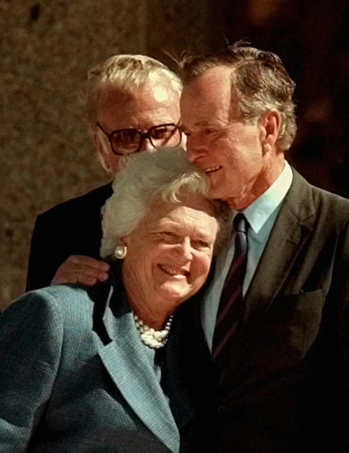 Former President George H.W. Bush hugs his wife, Barbara, after speaking at the dedication of the George Bush Presidential Library in College Station, TX., on Nov. 6, 1997. (AP Photo/Pat Sullivan)