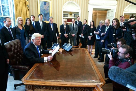 President Donald Trump talks with reporters in the Oval Office of the White House in Washington on Jan. 24, 2017, before signing an executive order on the Dakota Access pipeline. (AP Photo/Evan Vucci)