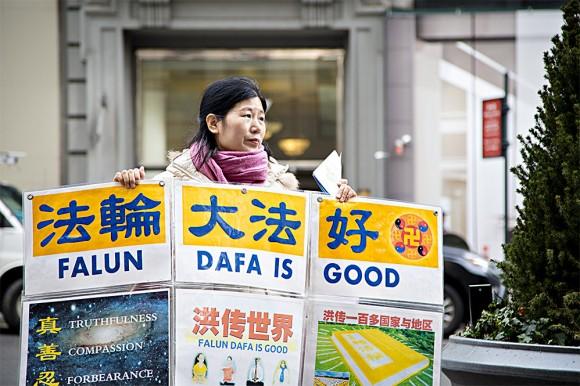 Wang Huijuan, in front of the Empire State Building in Manhattan, New York, on Jan. 12, 2017, holds a display to help Chinese tourists understand the facts about the persecution of Falun Gong in China. (Samira Bouaou/Epoch Times)