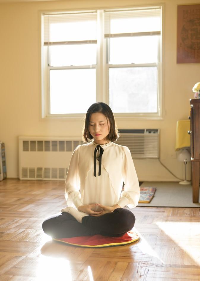 Li Fuyao demonstrates her meditation practice at her home in Queens, New York, on Jan. 8, 2016. She and her parents escaped China in 2014 and were granted asylum after years of torture for practicing Falun Gong. (Samira Bouaou/Epoch Times)