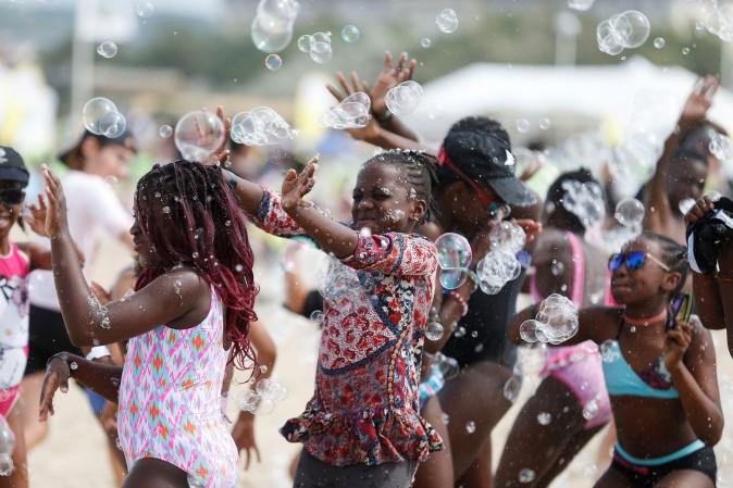 Children play with soap bubble along the beach in Deauville, northwestern France, as part of the "Forgotten by the Holidays" campaign organized by the French NGO Secours Populaire for children whose families can not afford to go on holidays on on Aug. 23. (CHARLY TRIBALLEAU/AFP/Getty Images)