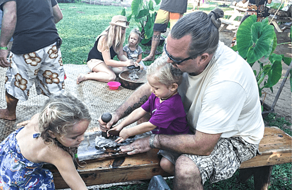 Michael Young pounds poi with his daughter Mila (L) and son Manu at the 2016 Waipa Festival in Kauai, Hawaii. (Courtesy of Michael Young)