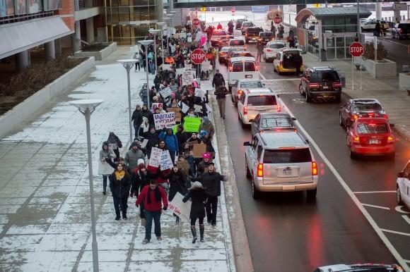 People march back to their cars during a protest against an executive order on immigration from President Trump at Gerald R. Ford International Airport in Grand Rapids on Jan. 29, 2017. (Neil Blake/The Grand Rapids Press via AP)