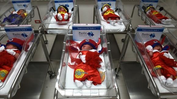 TOPSHOT - Newborn babies in Chinese-inspired costumes to mark the Year of the Rooster lay in cots at Paolo Memorial Hospital in Bangkok on January 27, 2017. (AFP/ Lillian Suwanrumpha)