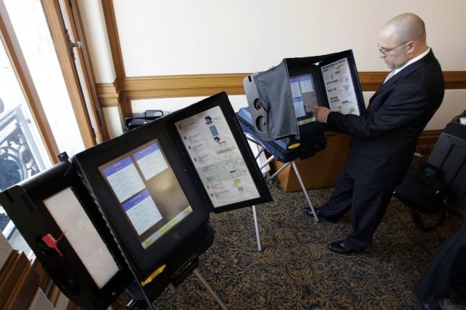 A sales executive with Sequoia Voting Systems demonstrates how the machine works in San Francisco on Dec. 5, 2007. (AP Photo/Paul Sakuma)