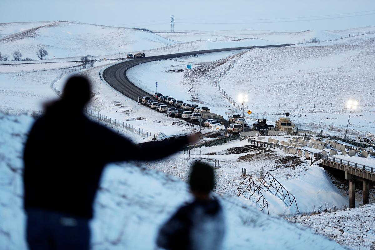 Law enforcement vehicles line a road leading to a blocked bridge next to the Oceti Sakowin camp where people have gathered to protest the Dakota Access oil pipeline in Cannon Ball, N.D., on Dec. 3, 2016. (AP Photo/David Goldman)