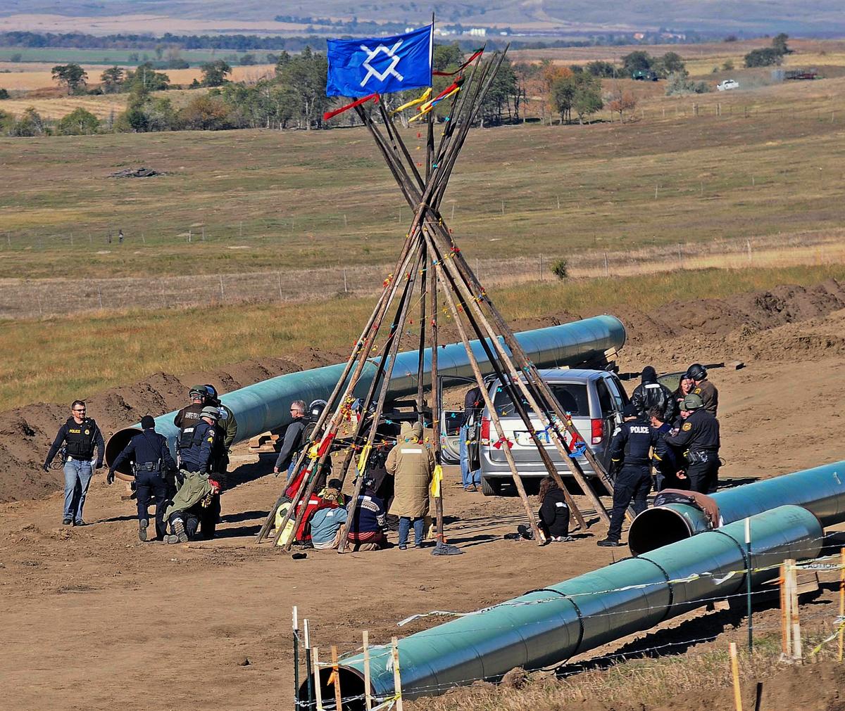 Law enforcement officers (L) drag a person from a protest against the Dakota Access Pipeline, near the town of St. Anthony in rural Morton County, N.D., on Oct. 10, 2016. (Tom Stromme/The Bismarck Tribune via AP)