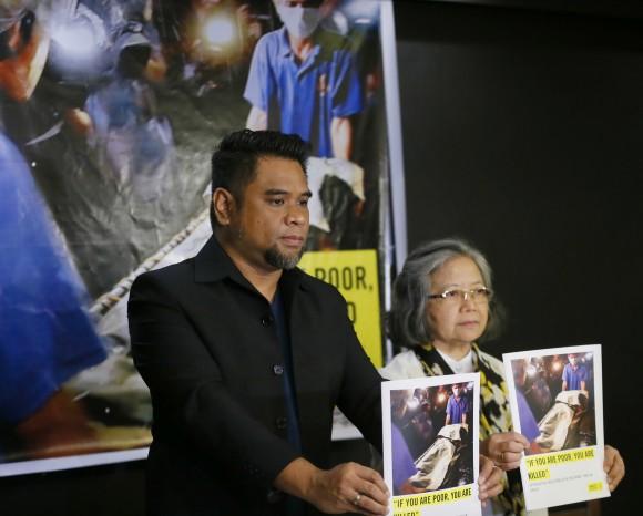 Amnesty International campaigner Wilnor Papa, left, and Board of Trustee Sis. Maria Vida Cordero hold copies of the Amnesty's repport on extra-judicial killings in the country following a video news conference with their London counterpart Rachel Chhoa-Howard, in suburban Quezon city, northeast of Manila, Philippines Wednesday, Feb. 1, 2017. (AP Photo/Bullit Marquez)