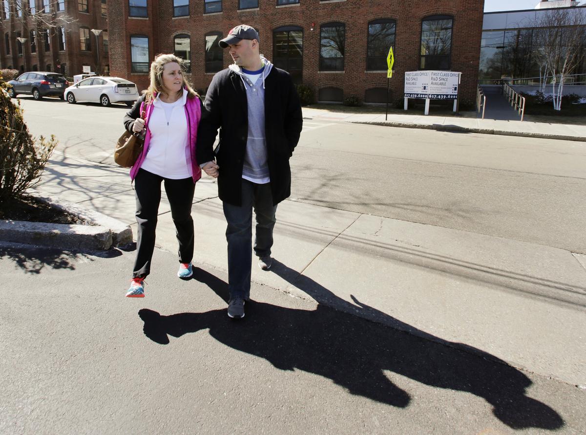 Boston Marathon bombing survivor Roseann Sdoia walks with her boyfriend, Boston firefighter Mike Materia, after her doctor's appointment in Newton, Mass., on March 18, 2014. (AP Photo/Charles Krupa, File)