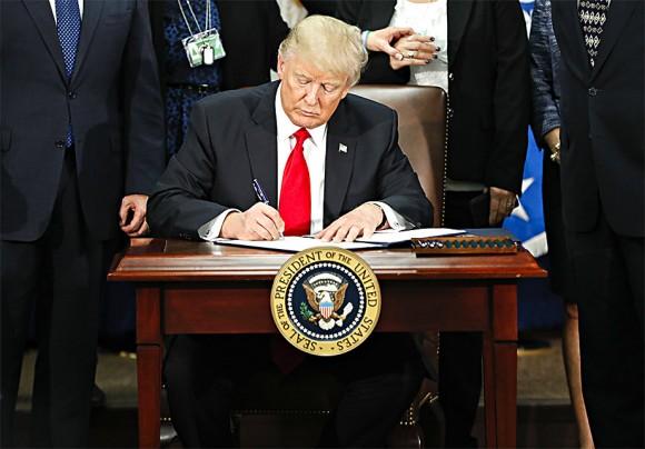President Donald Trump at the Department of Homeland Security in Washington on Jan. 25 signs an executive order for increased border security and immigration enforcement. (AP Photo/Pablo Martinez Monsivais)