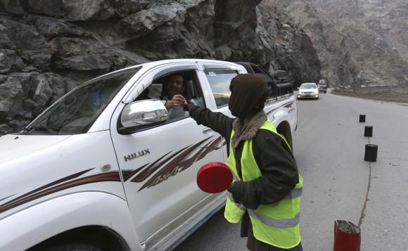 11-year-old Sedaqat receives a tip from a motorist on the Maipur Pass, along the main highway from Kabul to Pakistan, near Kabul, Afghanistan, on Jan. 5, 2017. (AP Photo/Rahmat Gul)