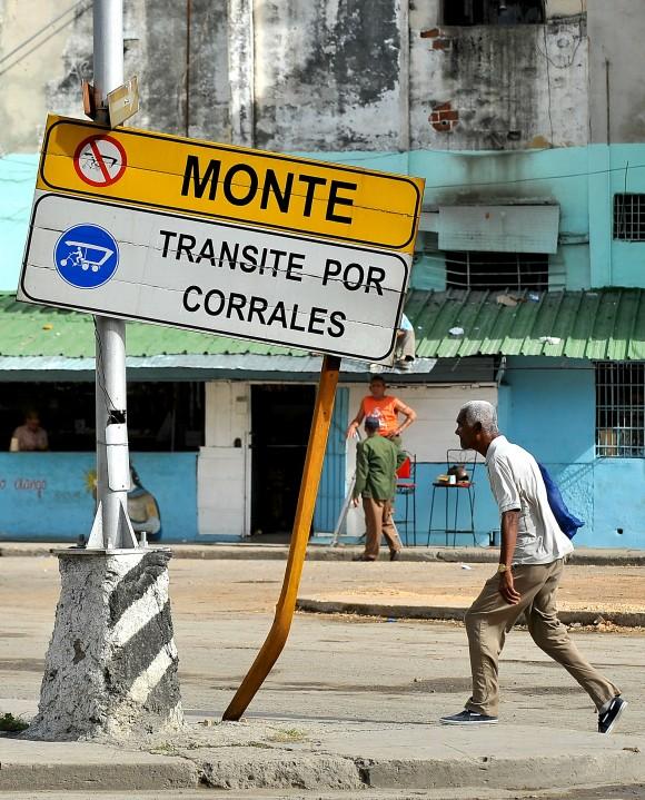 A man walks next to a traffic sign in Havana, on January 11, 2016. A third of the cars riding in Cuba do so with mechanical failures and on destroyed roads. AFP PHOTO/YAMIL LAGE / AFP / YAMIL LAGE (Photo credit should read YAMIL LAGE/AFP/Getty Images)