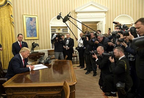 President Donald Trump signs his first executive order as president, ordering federal agencies to ease the burden of President Barack Obama's Affordable Care Act, at the White House on Jan. 20. (Kevin Dietsch - Pool/Getty Images)